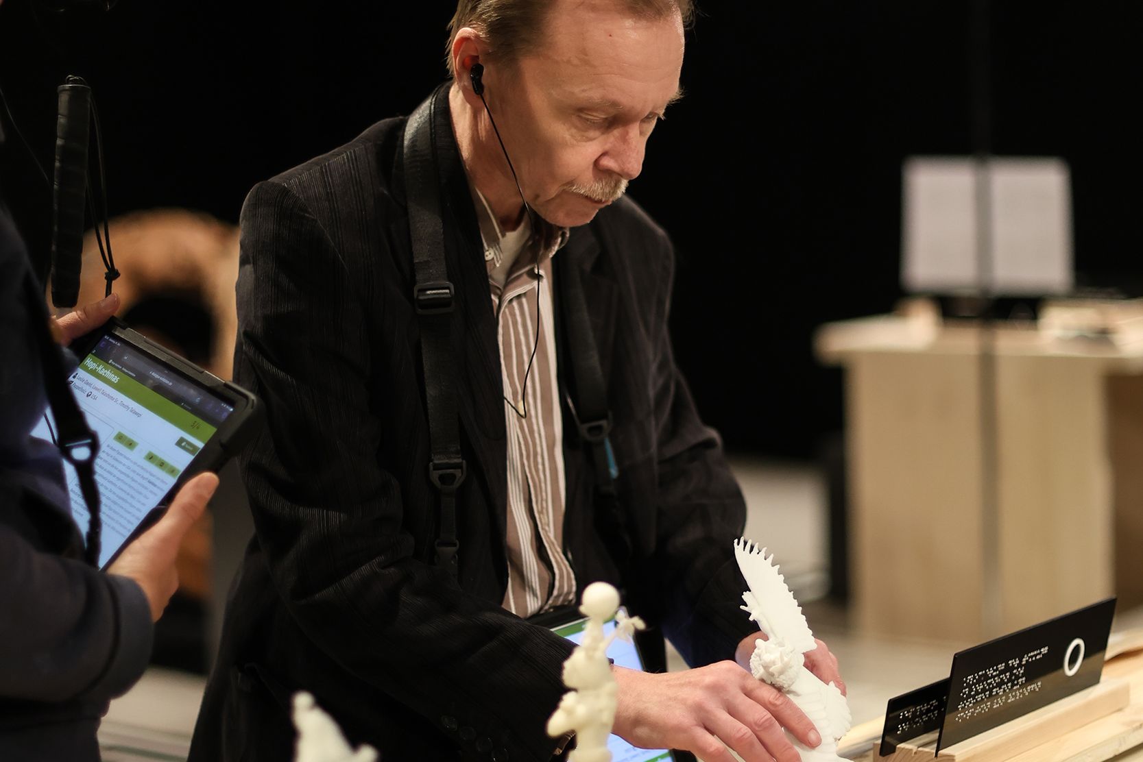 Mann in der Ausstellung tastet 3D-Modelle der Kachinas ab.